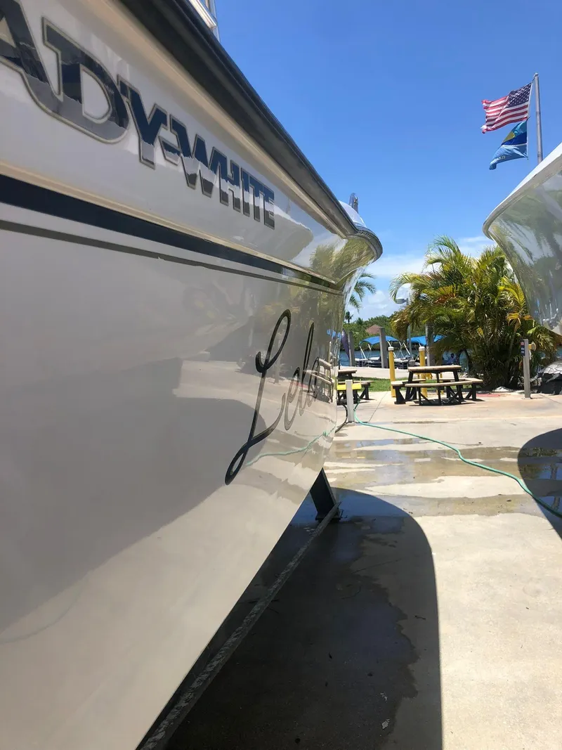 Slide: The Image of 1999 Grady-White 209 ESCAPE boat docked with flags in the background. - 10