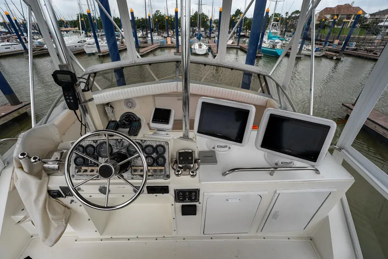 Slide: The Image of 1984 Bertram 33 Sport Fisherman boat helm with dual screens and steering wheel. - 10