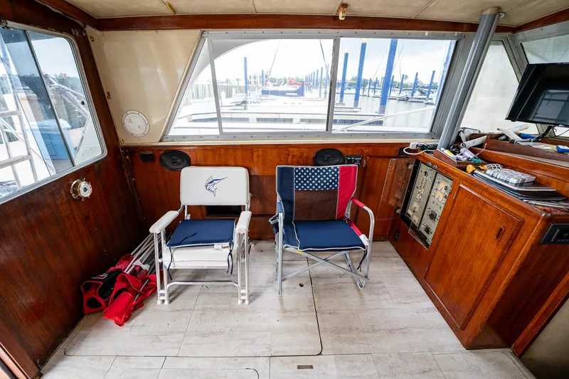 Slide: The Image of Interior of a 1984 Bertram 33 Sport Fisherman boat with two chairs and control panel. - 13
