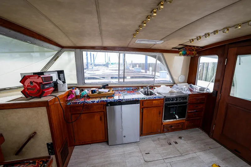Slide: The Image of Interior of 1984 Bertram 33 Sport Fisherman boat with kitchen appliances and wooden cabinetry. - 15