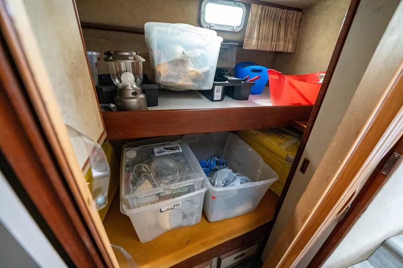 Slide: The Image of Storage area inside a 1984 Bertram 33 Sport Fisherman boat with various containers and supplies. - 17