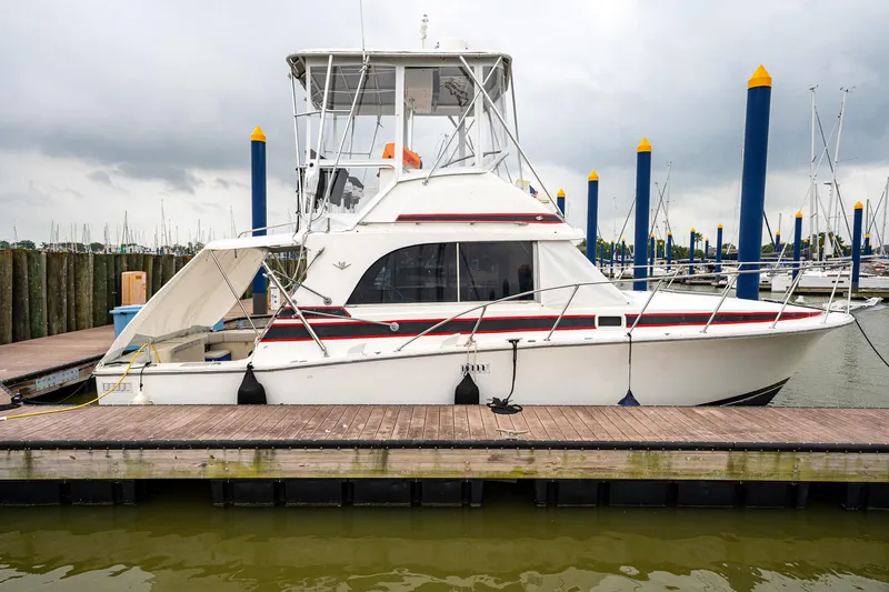 Slide: The Image of 1984 Bertram 33 Sport Fisherman docked at marina. - 2