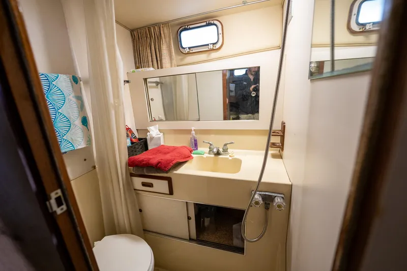 Slide: The Image of 1984 Bertram 33 Sport Fisherman boat bathroom with sink, mirror, and toilet. - 21
