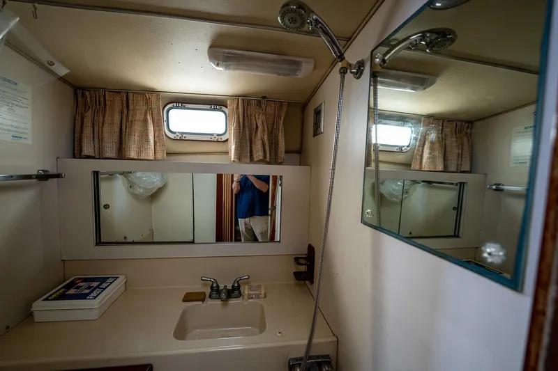 Slide: The Image of 1984 Bertram 33 Sport Fisherman bathroom with sink, mirror, and showerhead. - 22