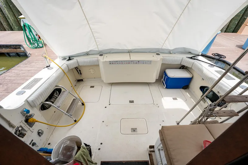 Slide: The Image of 1984 Bertram 33 Sport Fisherman boat deck with seating and storage compartments. - 8