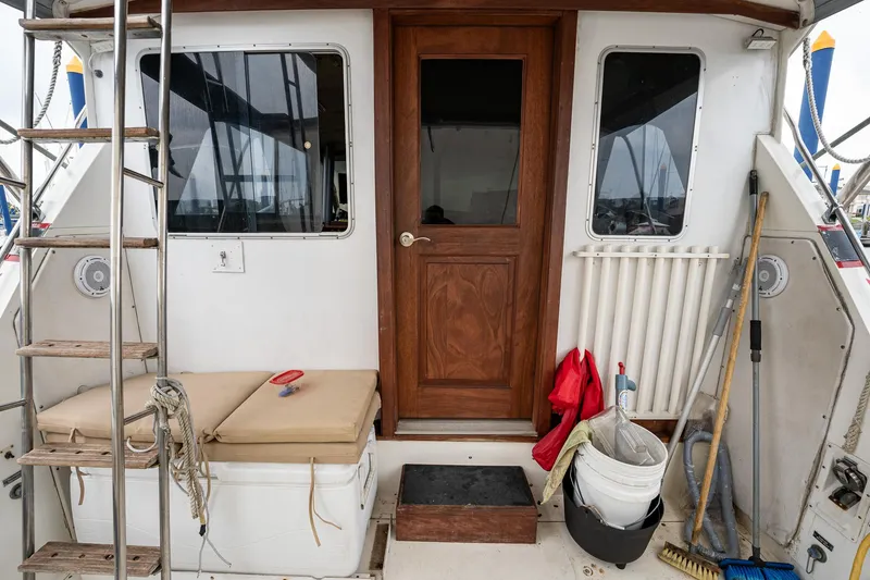 Slide: The Image of 1984 Bertram 33 Sport Fisherman boat deck with wooden door, ladder, and fishing gear. - 9