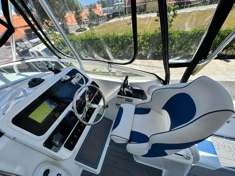 Slide: The Image of 2002 Century 3200 Walk-Around boat cockpit with steering wheel and captain's chair. - 11