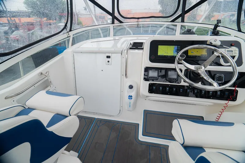 Slide: The Image of 2002 Century 3200 Walk-Around boat cockpit with steering wheel and navigation equipment. - 12