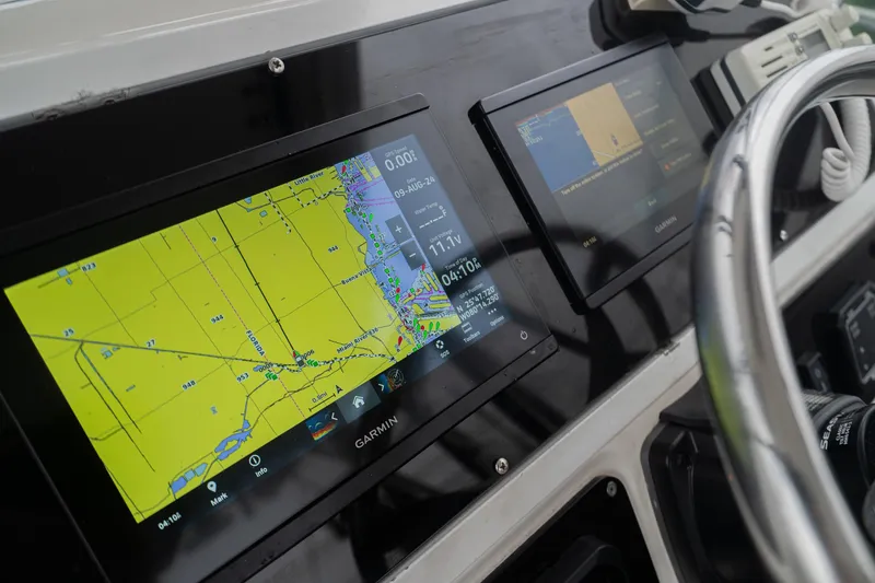 Slide: The Image of Century 3200 Walk-Around 2002 boat dashboard with Garmin navigation displays. - 15