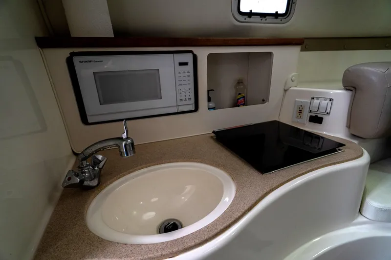 Slide: The Image of Compact kitchen area in 2002 Century 3200 Walk-Around boat with sink, stove, and microwave. - 23