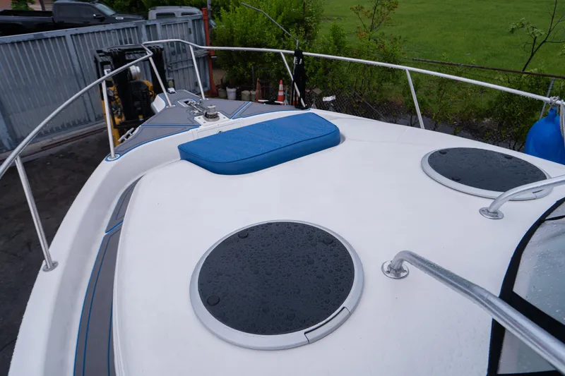 Slide: The Image of 2002 Century 3200 Walk-Around boat deck with blue cushion and circular hatches. - 3