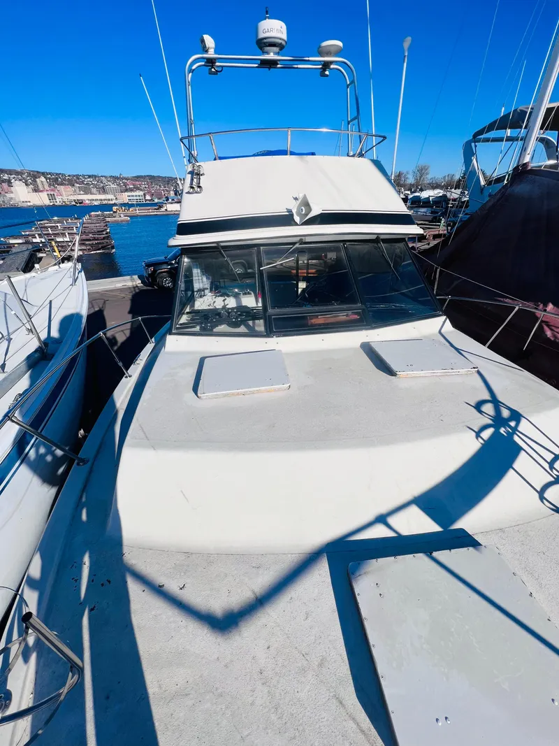 Slide: The Image of 1976 Trojan F 32 boat docked at a marina under clear blue skies. - 2