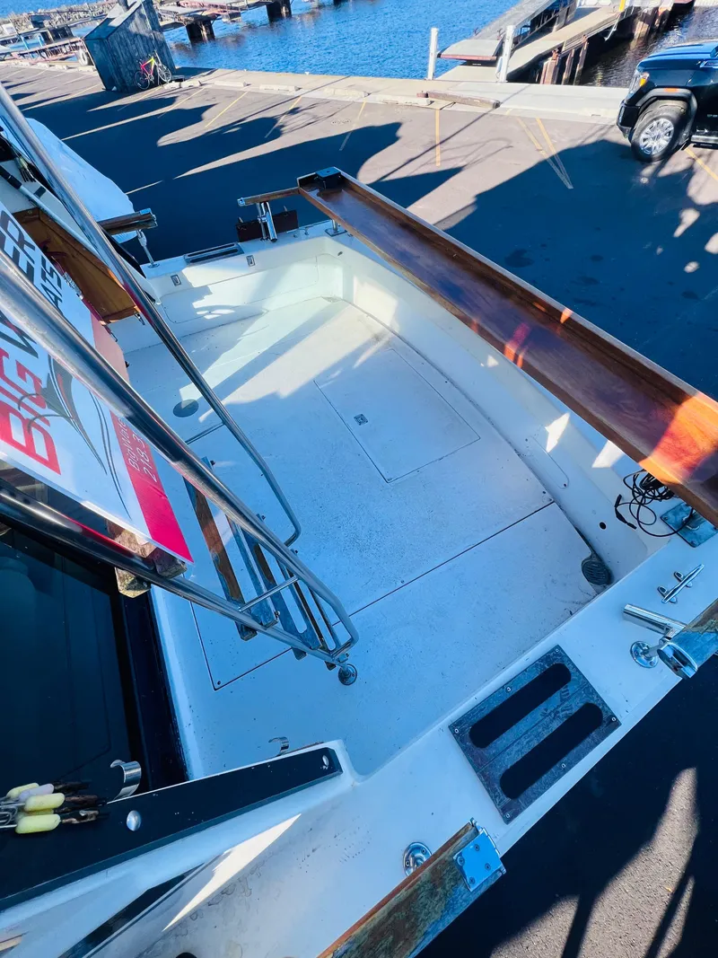 Slide: The Image of 1976 Trojan F 32 boat deck with wooden railings, docked at a marina. - 3