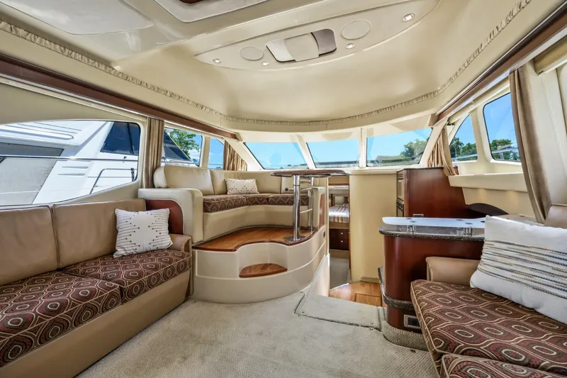 Slide: The Image of Luxurious interior of 2005 Sea Ray 420 Sedan Bridge yacht with plush seating and panoramic windows. - 13