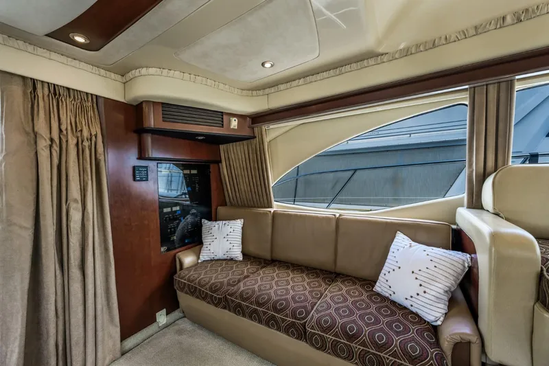 Slide: The Image of Luxurious interior of 2005 Sea Ray 420 Sedan Bridge with plush seating and large window. - 17