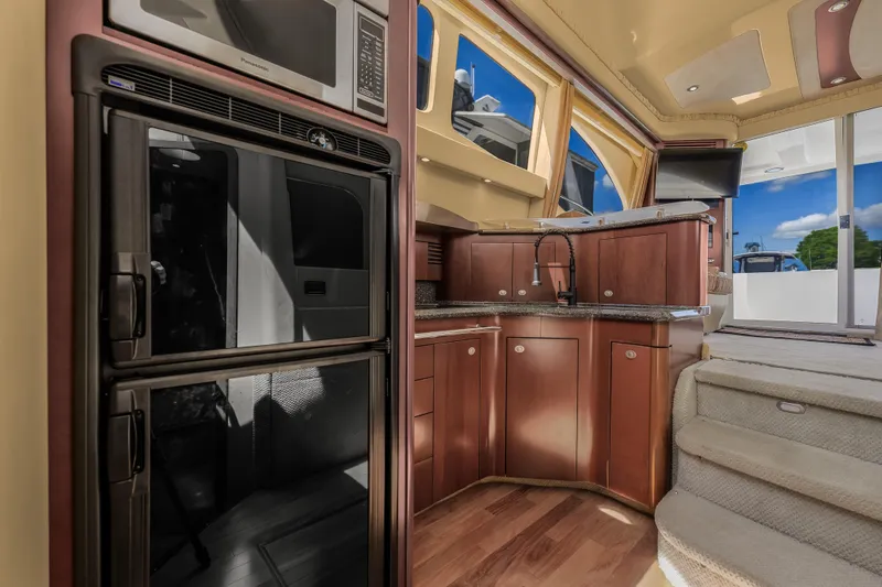 Slide: The Image of Interior of 2005 Sea Ray 420 Sedan Bridge yacht with modern kitchen and wooden cabinetry. - 18