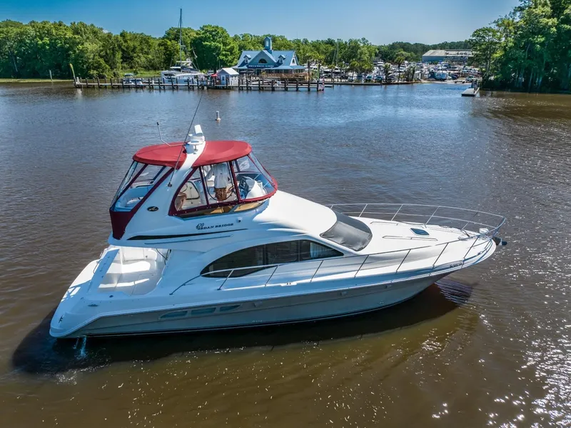 Slide: The Image of 2005 Sea Ray 420 Sedan Bridge yacht cruising on a calm river. - 2