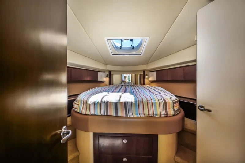 Slide: The Image of 2005 Sea Ray 420 Sedan Bridge bedroom with skylight and striped bedding. - 22