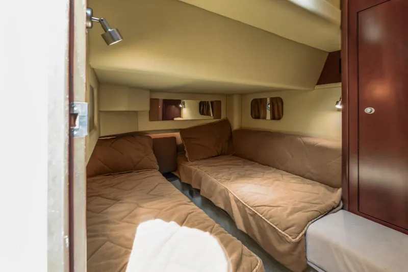 Slide: The Image of 2005 Sea Ray 420 Sedan Bridge cabin with twin beds and cozy lighting. - 24