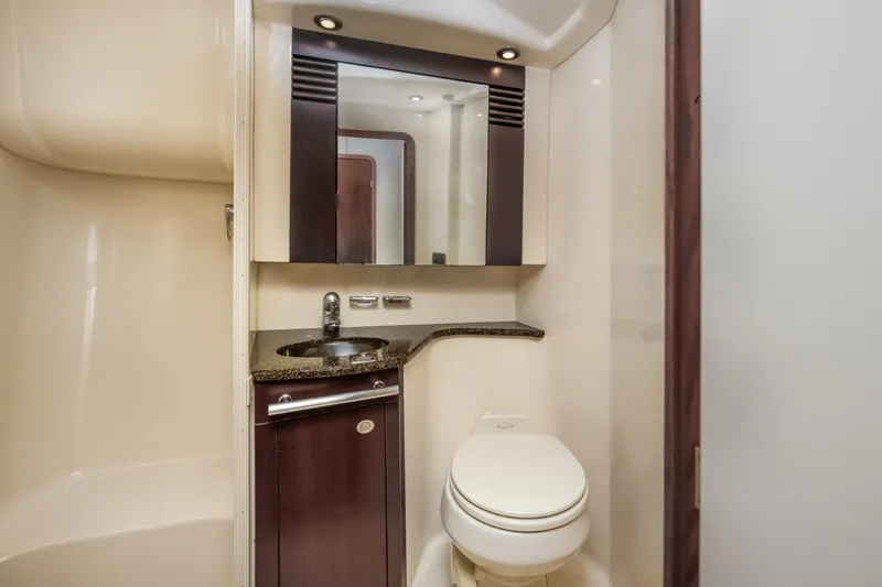 Slide: The Image of 2005 Sea Ray 420 Sedan Bridge bathroom with modern fixtures and dark wood cabinetry. - 25