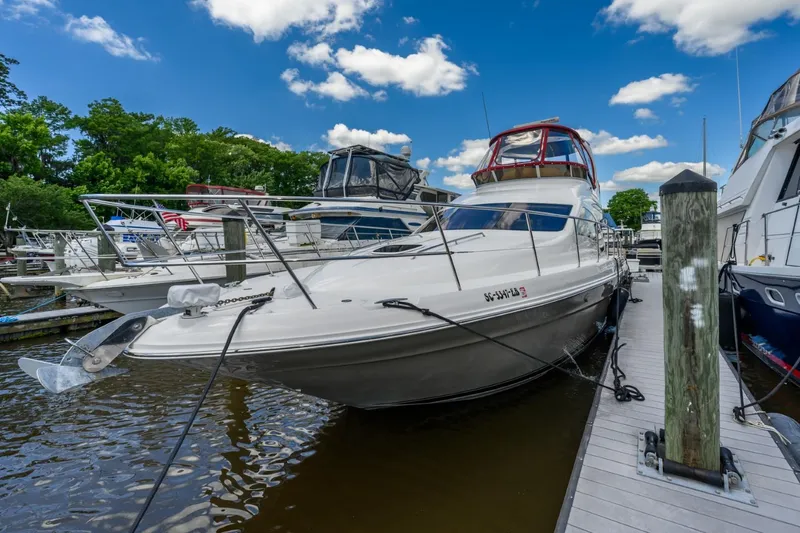 Slide: The Image of 2005 Sea Ray 420 Sedan Bridge docked at a marina under a blue sky. - 6