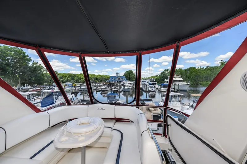 Slide: The Image of 2005 Sea Ray 420 Sedan Bridge interior view at marina with boats and trees. - 9