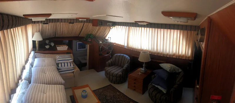 Slide: The Image of Interior of 1981 Hatteras 48 Motor Yacht with cozy seating and striped bedding. - 10