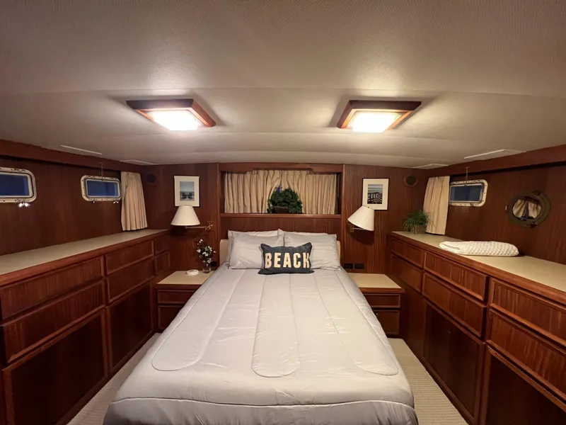 Slide: The Image of Cozy bedroom in 1981 Hatteras 48 Motor Yacht with wood paneling and nautical decor. - 11