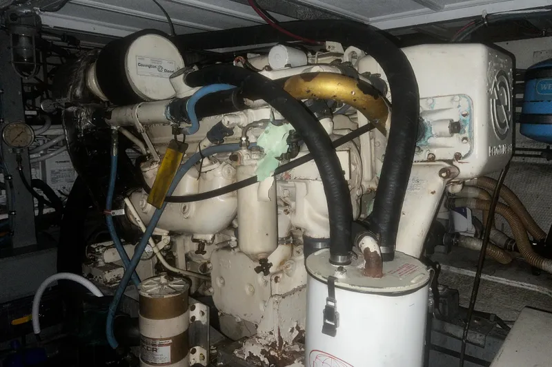 Slide: The Image of Engine room of a 1981 Hatteras 48 Motor Yacht with visible components and hoses. - 22