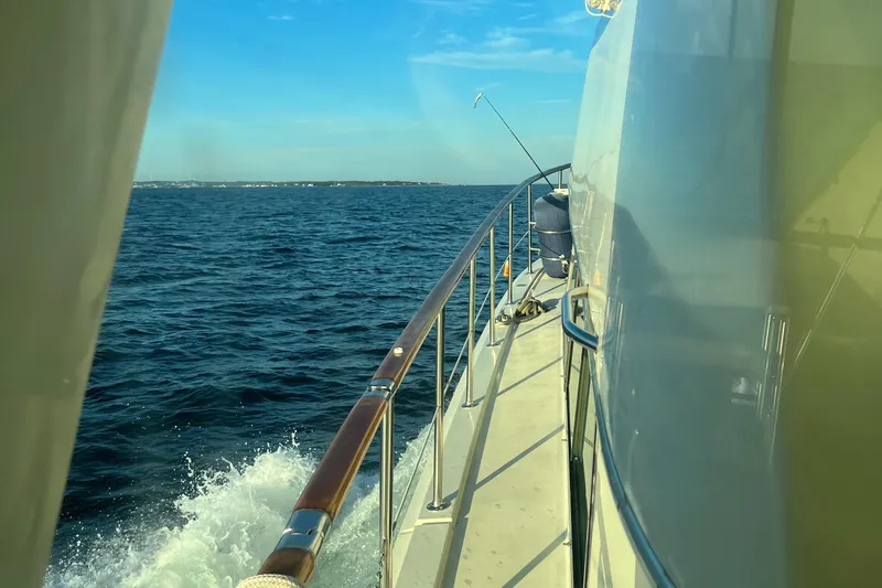 Slide: The Image of 1981 Hatteras 48 Motor Yacht cruising on open sea under clear blue sky. - 4
