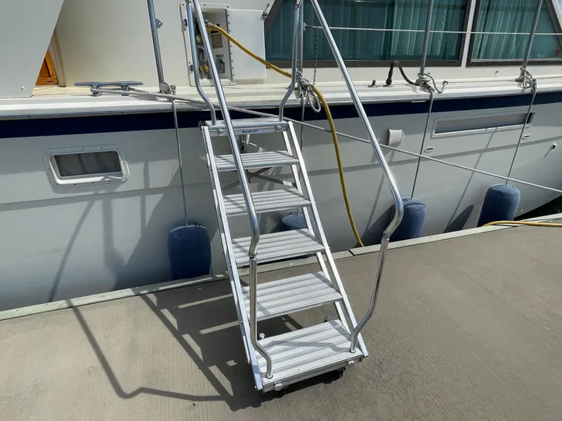 Slide: The Image of Stairway leading to a 1981 Hatteras 48 Motor Yacht docked at a marina. - 5