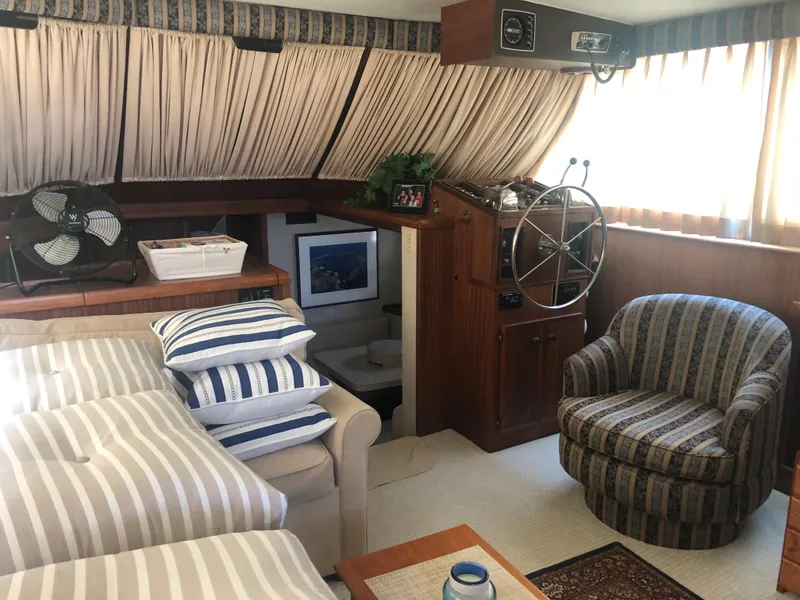Slide: The Image of Interior of 1981 Hatteras 48 Motor Yacht with striped cushions and wooden helm. - 9