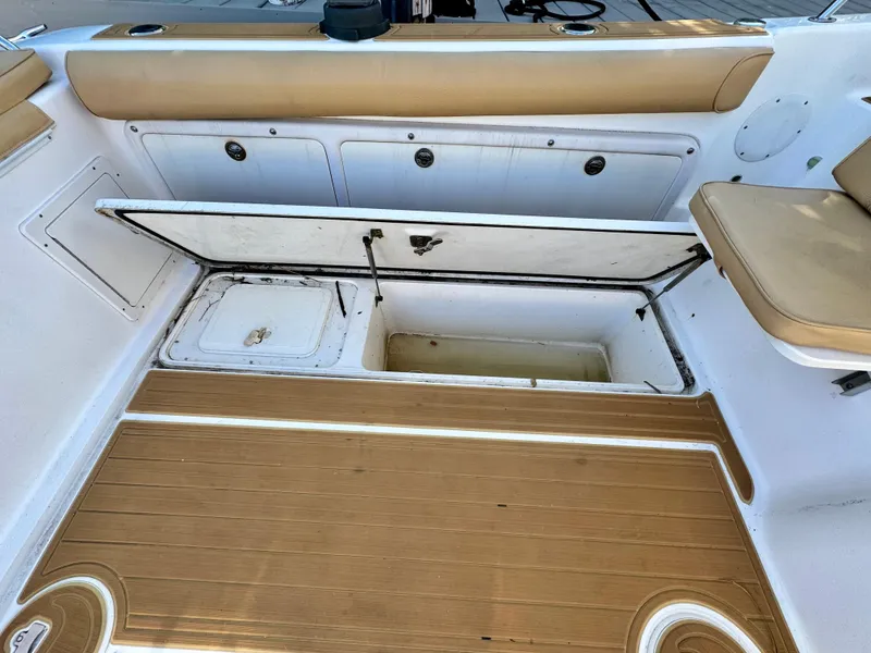 Slide: The Image of 2006 Century 3200 Walk-Around boat with open storage compartments and cushioned seating. - 21