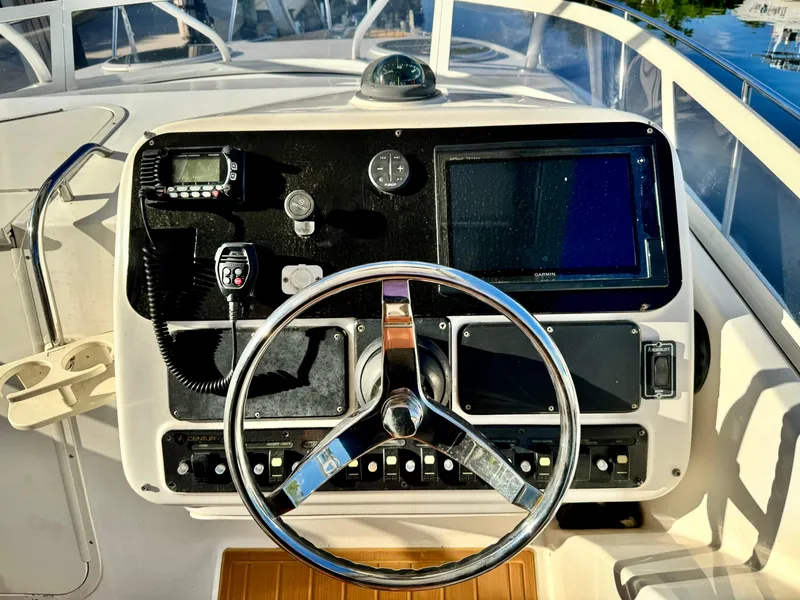 Slide: The Image of 2006 Century 3200 Walk-Around boat dashboard with steering wheel and navigation equipment. - 9