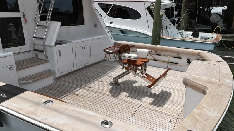Slide: The Image of 1996 Donzi Custom Enclosed Flybridge boat deck with fishing chair and storage compartments. - 10