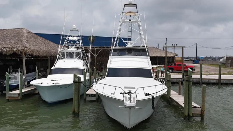Slide: The Image of Two 1996 Donzi Custom Enclosed Flybridge boats docked at a marina. - 14