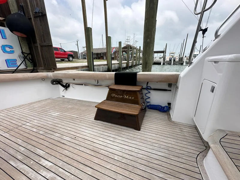 Slide: The Image of 1996 Donzi Custom Enclosed Flybridge boat deck with wooden steps at a marina. - 25