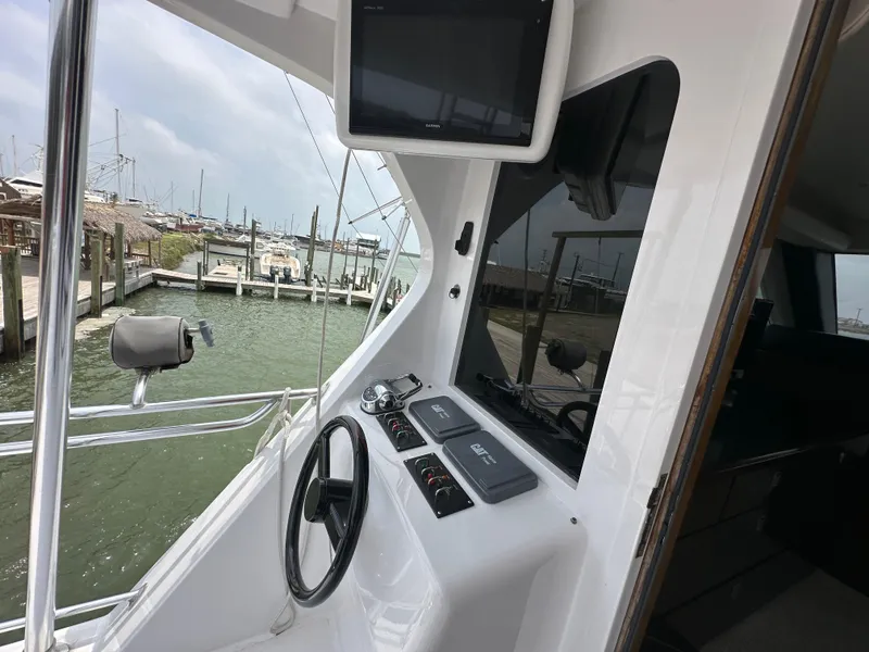 Slide: The Image of 1996 Donzi Custom Enclosed Flybridge helm with steering wheel and control panel. - 30
