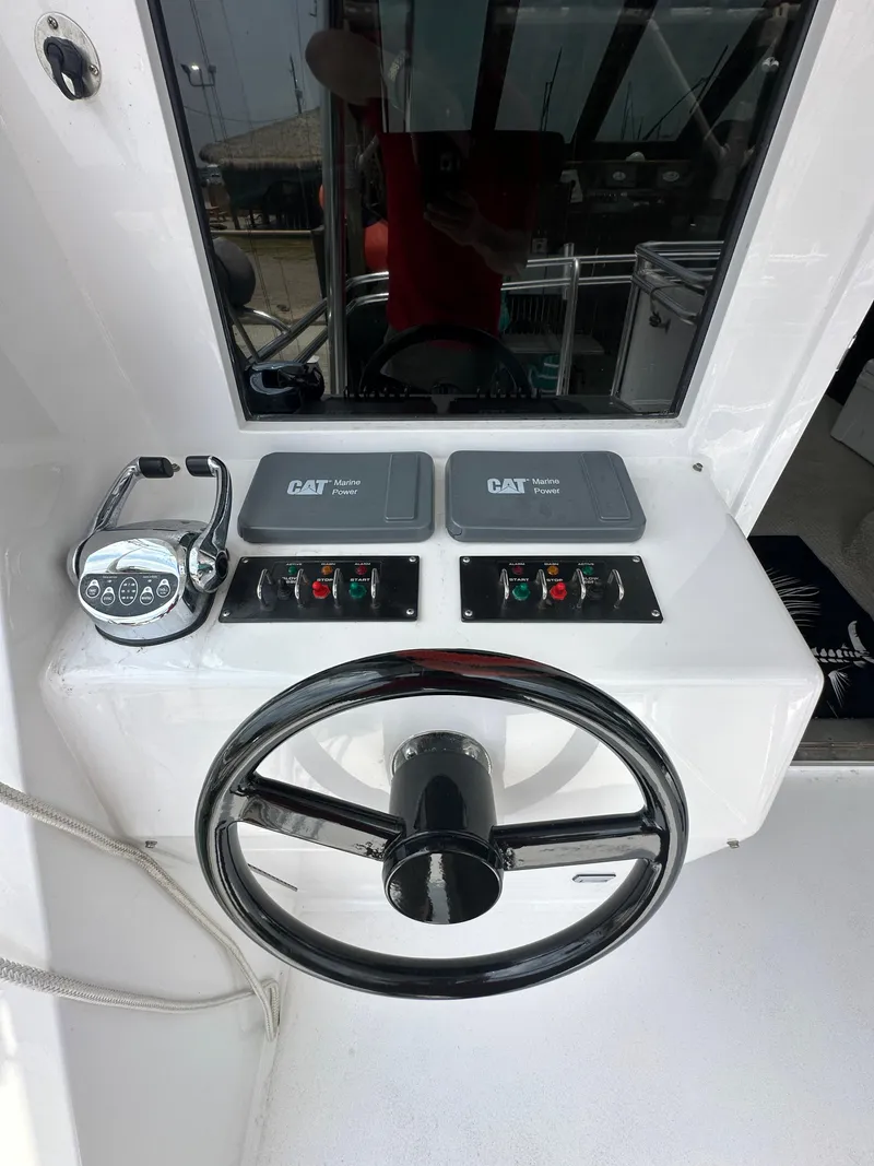 Slide: The Image of 1996 Donzi Custom Enclosed Flybridge helm with steering wheel and control panels. - 32