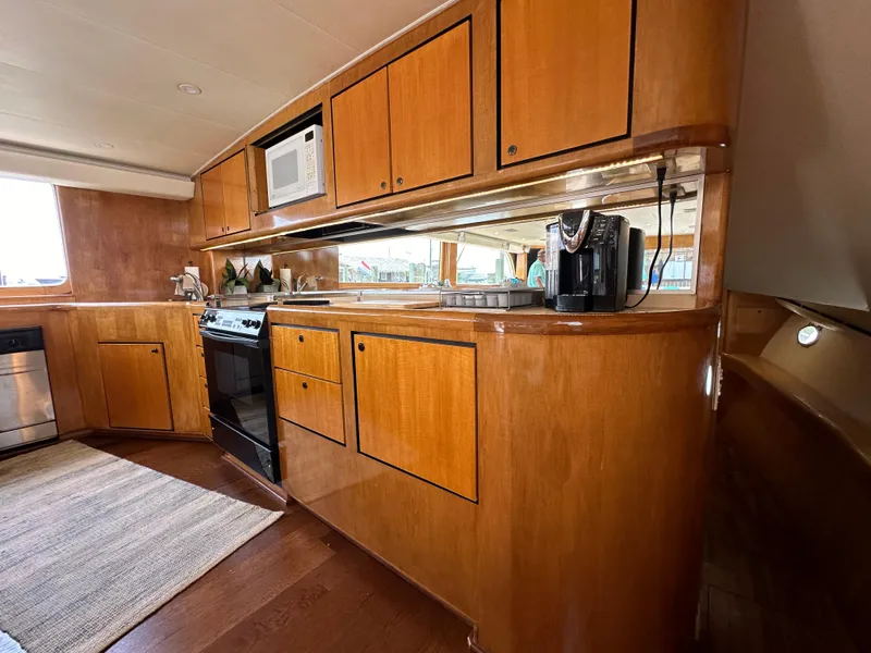 Slide: The Image of 1996 Donzi Custom Enclosed Flybridge kitchen with wooden cabinets and modern appliances. - 44