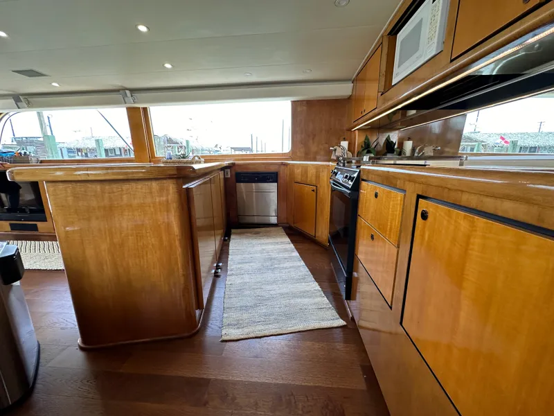 Slide: The Image of 1996 Donzi Custom Enclosed Flybridge kitchen with wooden cabinetry and modern appliances. - 45