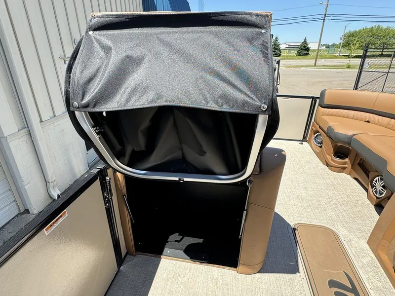 Slide: The Image of 2024 Tahoe Cascade 2385 EL boat interior with storage compartment open. - 12