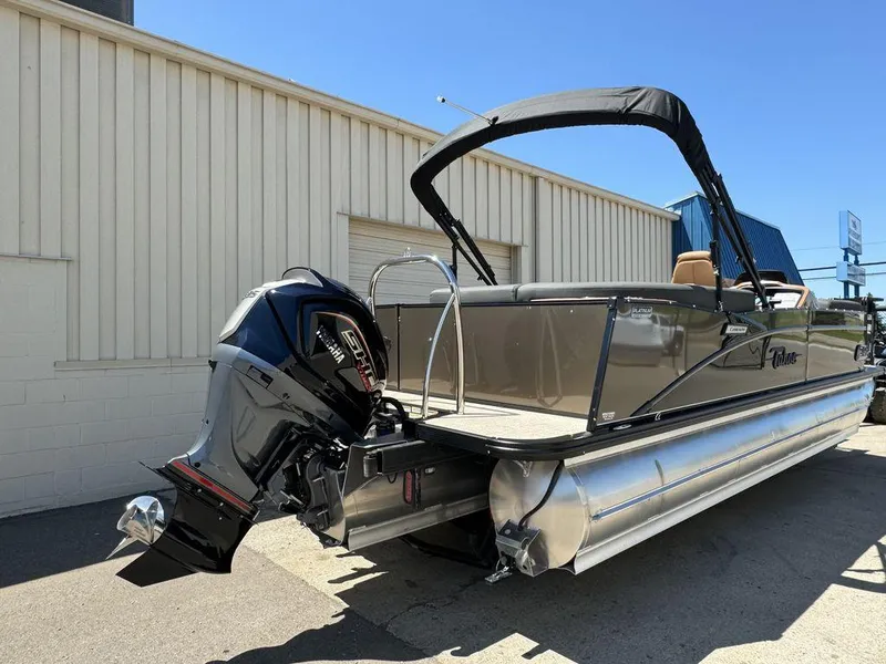 Slide: The Image of 2024 Tahoe Cascade 2385 EL pontoon boat with outboard motor, docked outdoors. - 13