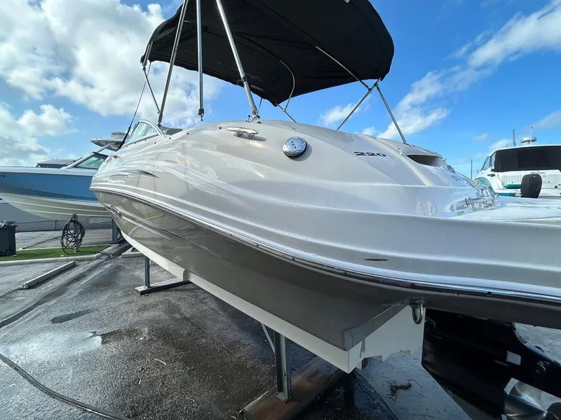 Slide: The Image of 2007 Sea Ray 220 Sundeck boat on a lift with a black canopy. - 12