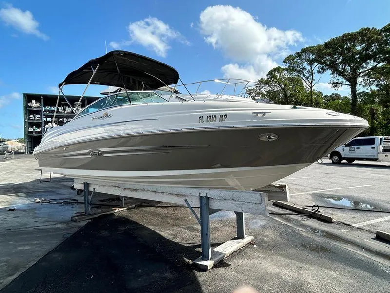 Slide: The Image of 2007 Sea Ray 220 Sundeck boat on a trailer in a marina. - 17