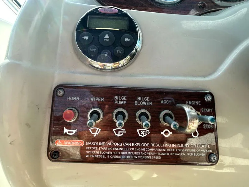Slide: The Image of Control panel of a 2007 Sea Ray 220 Sundeck boat with various switches and warning label. - 28