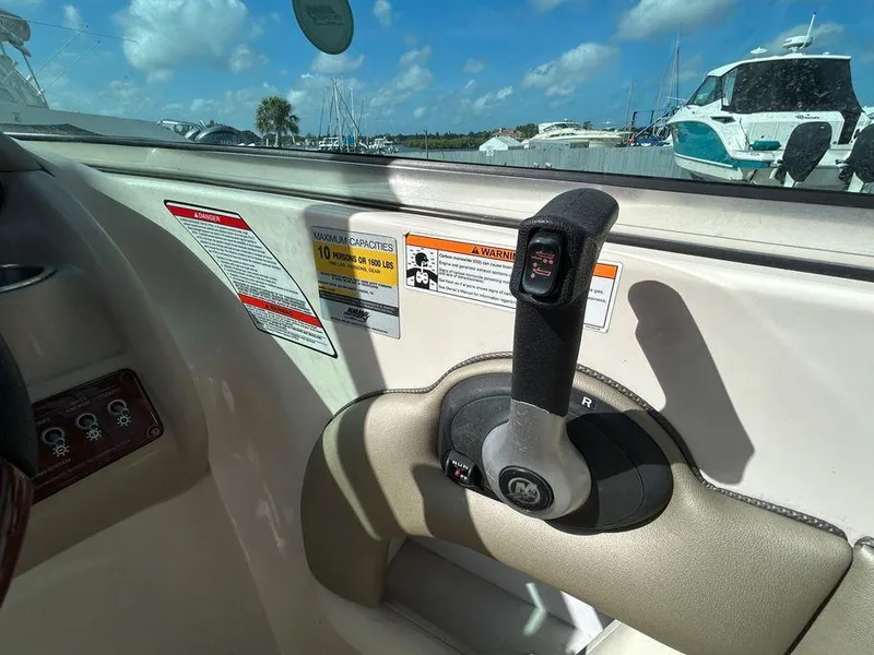 Slide: The Image of 2007 Sea Ray 220 Sundeck throttle control and warning labels with marina background. - 30