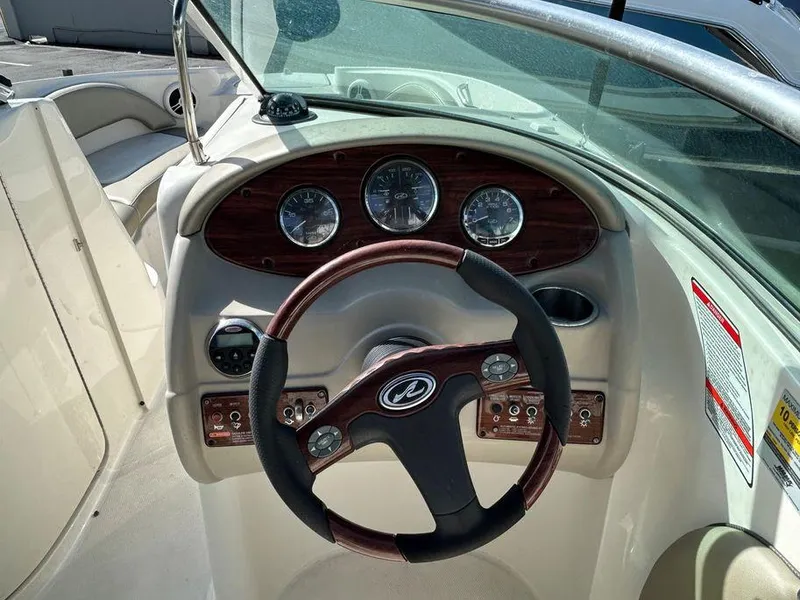 Slide: The Image of 2007 Sea Ray 220 Sundeck boat dashboard with steering wheel and gauges. - 5