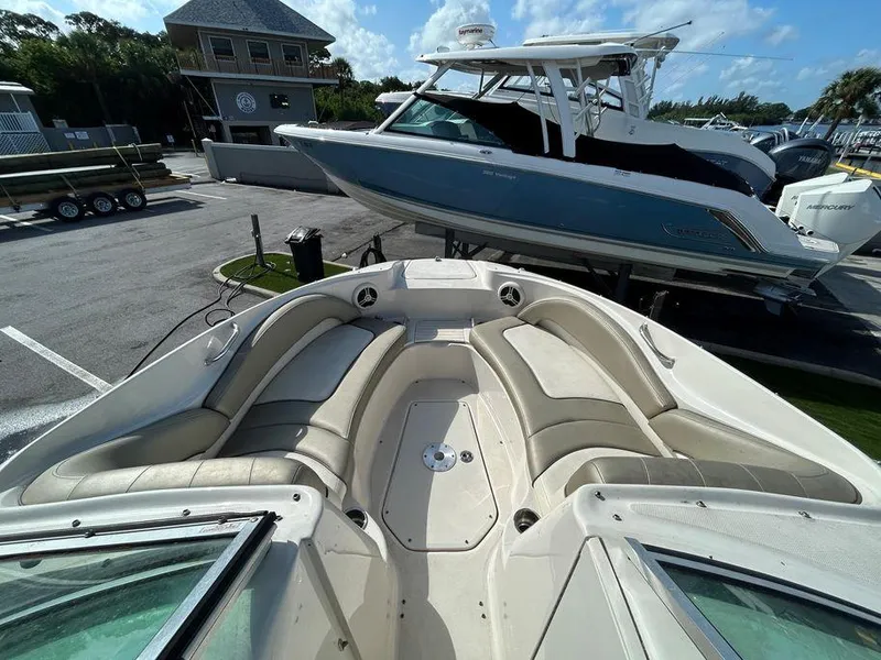 Slide: The Image of 2007 Sea Ray 220 Sundeck boat with spacious seating at a marina. - 7