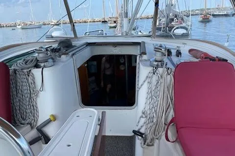 Slide: The Image of Cockpit of 2005 Beneteau 423 sailboat with red cushions and marina view. - 19